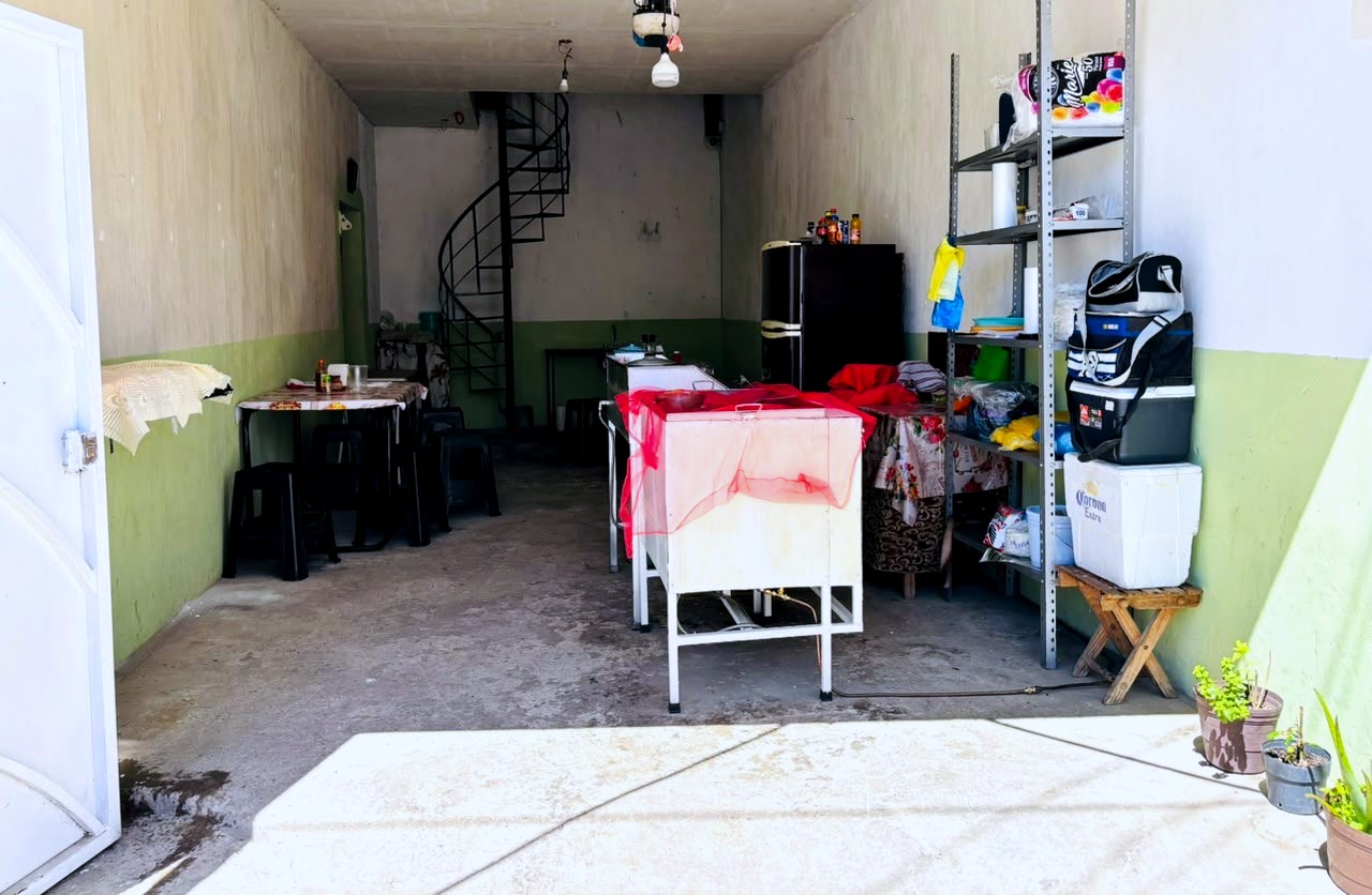 Entrada de Taquería Mi Chuchu con puerta blanca y macetas